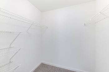Empty walk-in closet with white walls and shelves at acclaim at sterling in sterling, 20164